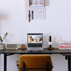 Bàn làm việc tối giản với loa Marshall Emberton, tai nghe Marshall Major, laptop hiển thị District M