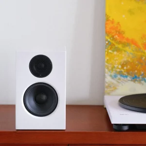 Loa bookshelf Audio Pro A28W màu trắng và góc mâm đĩa than TEAC TN-180BT-A3 cùng tông màu trên kệ gỗ