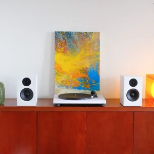 Combo mâm đĩa than TEAC TN-180BT-A3 và cặp loa bookshelf Audio Pro A28W màu trắng trên kệ gỗ, tranh trừu tượng phía sau