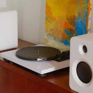 Mâm đĩa than TEAC TN-180BT-A3 trắng và loa bookshelf Kanto REN trên kệ gỗ hiện đại, tranh abstract