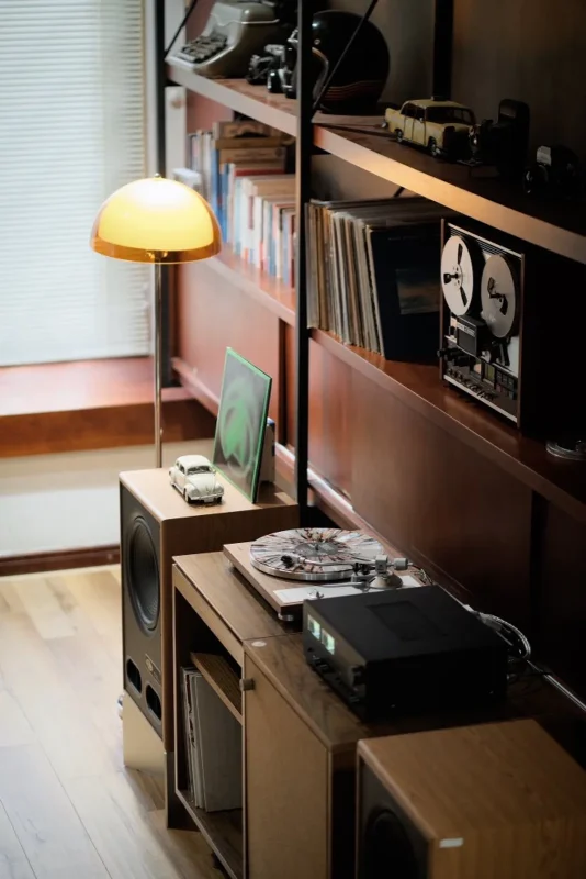 Góc chụp từ trên: mâm TEAC, ampli NAD đồng hồ VU xanh và loa Vestlyd V12C trong phòng nghe đầy sách và đồ vintage