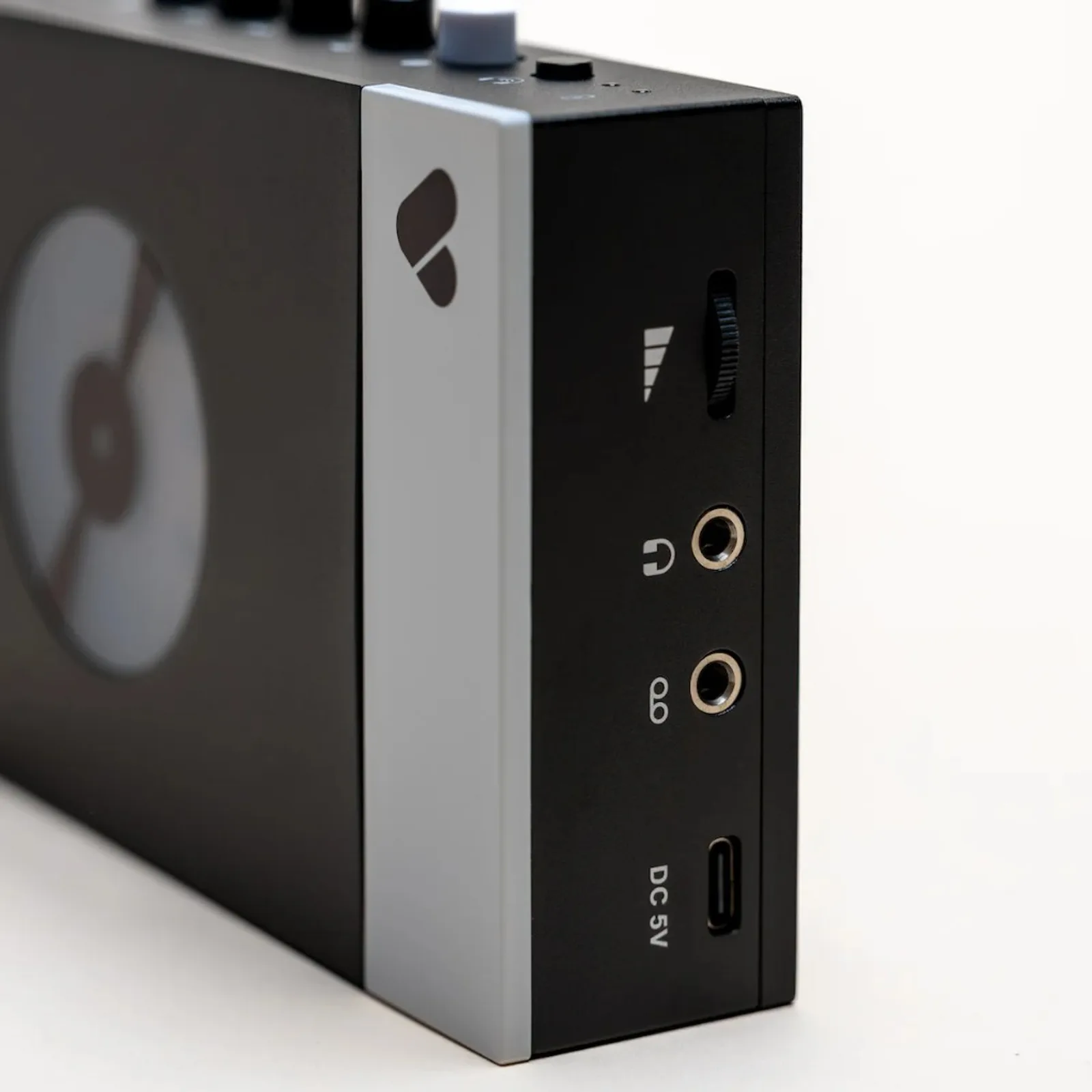 Cạnh máy Discogs × We Are Rewind: logo Discogs, núm volume, hai jack 3,5 mm và cổng sạc USB-C DC 5V