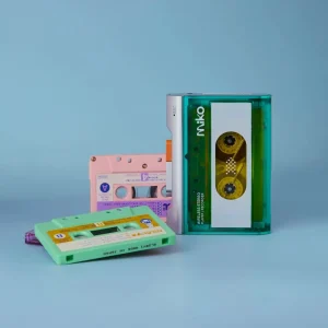 Gadhouse MIKO Mint đứng cạnh băng cassette màu mint, hồng và tím, nền xanh pastel studio