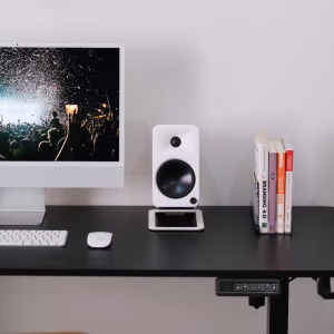 iMac màn hình concert, loa studio trắng, bàn phím chuột Apple, sách Branding 4.0 và Atomic Habits, bàn đứng có bảng điều khiển