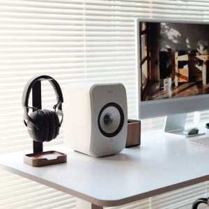 Loa KEF LSX II LT đá cạnh tai nghe Marshall đen trên giá gỗ, iMac màn hình nội thất gỗ, rèm sáng
