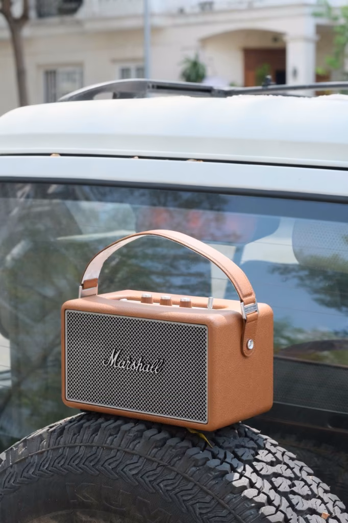 Loa Marshall Kilburn II đặt trên lốp dự phòng xe trắng, phong cách outdoor lifestyle