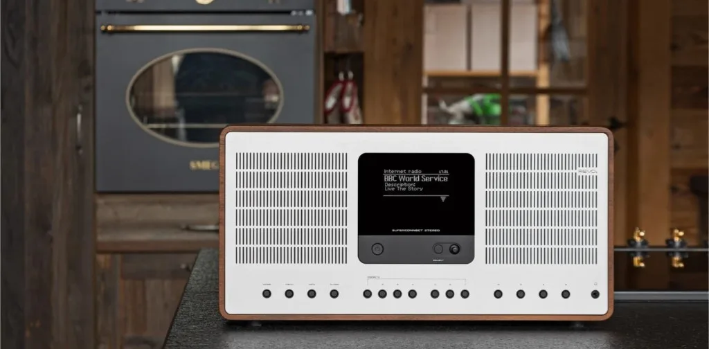 REVO SuperConnect Stereo walnut mặt trắng đặt trên mặt bếp đá, phòng bếp hiện đại với tủ gỗ và lò nướng