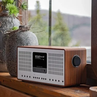 REVO SuperConnect Stereo walnut silver trong phòng phong cách rustic, cạnh đèn bàn gỗ và cửa sổ sáng