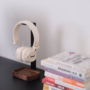 Tai nghe Marshall Major trên giá đỡ tối giản cạnh chồng sách trên bàn đen