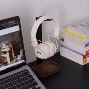 Tai nghe Marshall trên giá đỡ giữa laptop và chồng sách