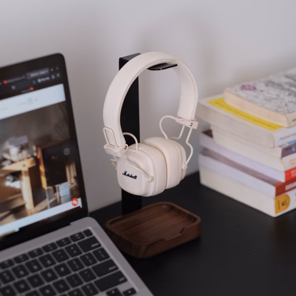 Tai nghe Marshall trên giá đỡ giữa laptop và chồng sách