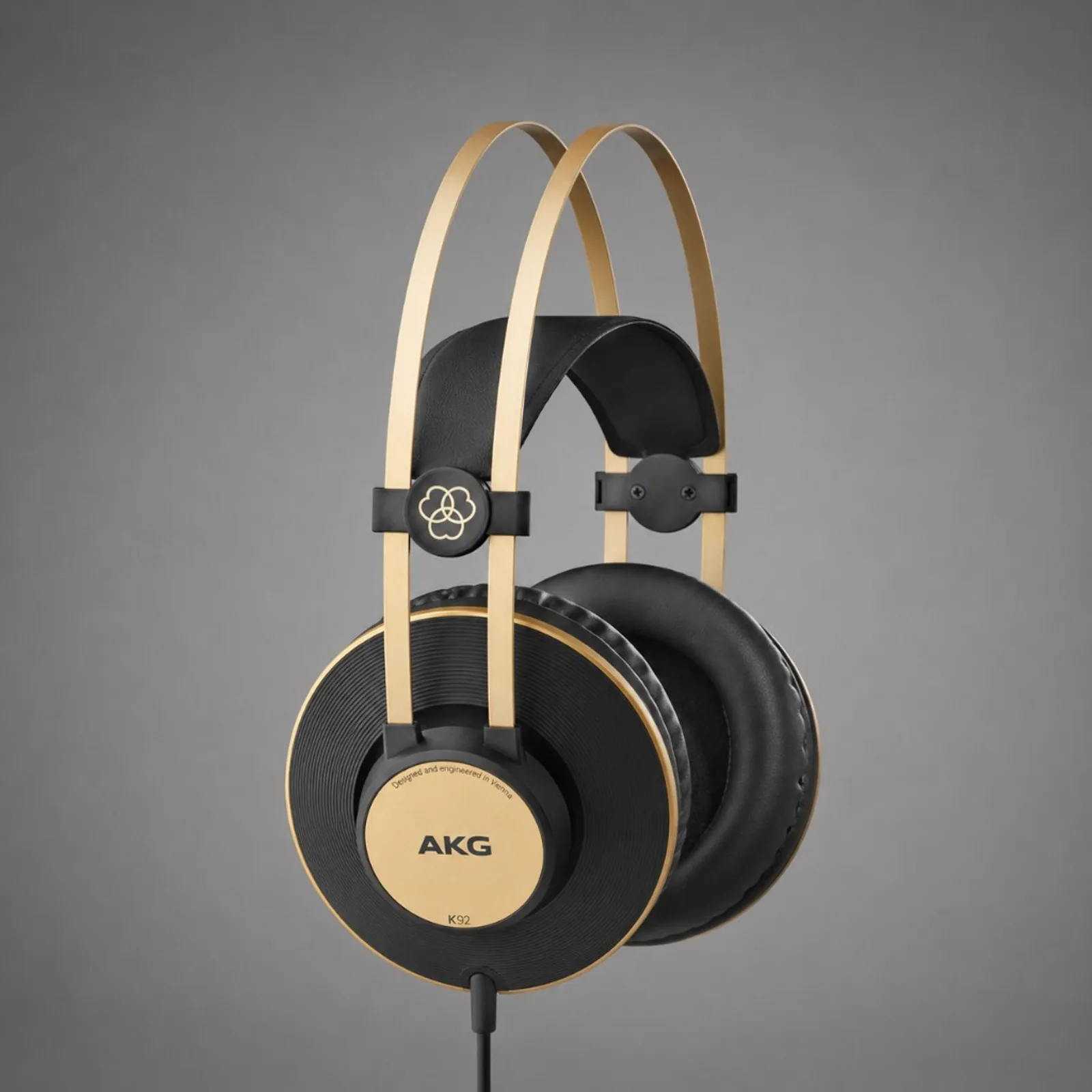 Tai nghe AKG K92 màu đen viền vàng trên nền xám, thiết kế closed-back dạng studio monitor