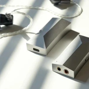 Hai AK HC4 trên nền trắng có vân bóng rèm: cổng 3,5 mm và 4,4 mm cân bằng, USB-C, công tắc DAR, IEM dây bạc phía sau.