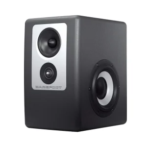 Barefoot Footprint02 Gen2 góc ba phần tư nền trắng: tấm bạc midrange và tweeter, LED xanh, woofer cone sáng bên hông phải với surround đen và ốc bắt