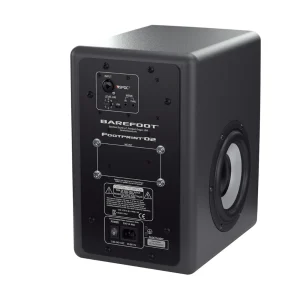 Barefoot Footprint02 Gen2 góc sau-phải: panel điều khiển đen với ốc lục giác, cổng và núm; thân thùng tối màu và woofer side-firing cone sáng bên hông