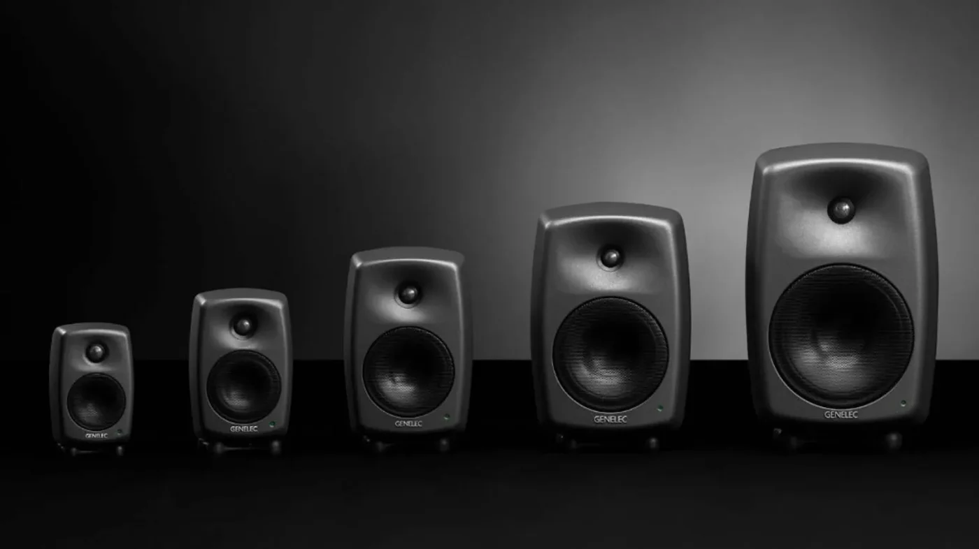 Các mẫu loa kiểm âm Genelec 8000 Series từ 8010 đến 8050 xếp theo kích thước tăng dần: thùng nhôm đúc MDE™, tweeter và woofer lưới kim loại, logo GENELEC, LED xanh lá, chân Iso-Pod™ trên nền studio tối.