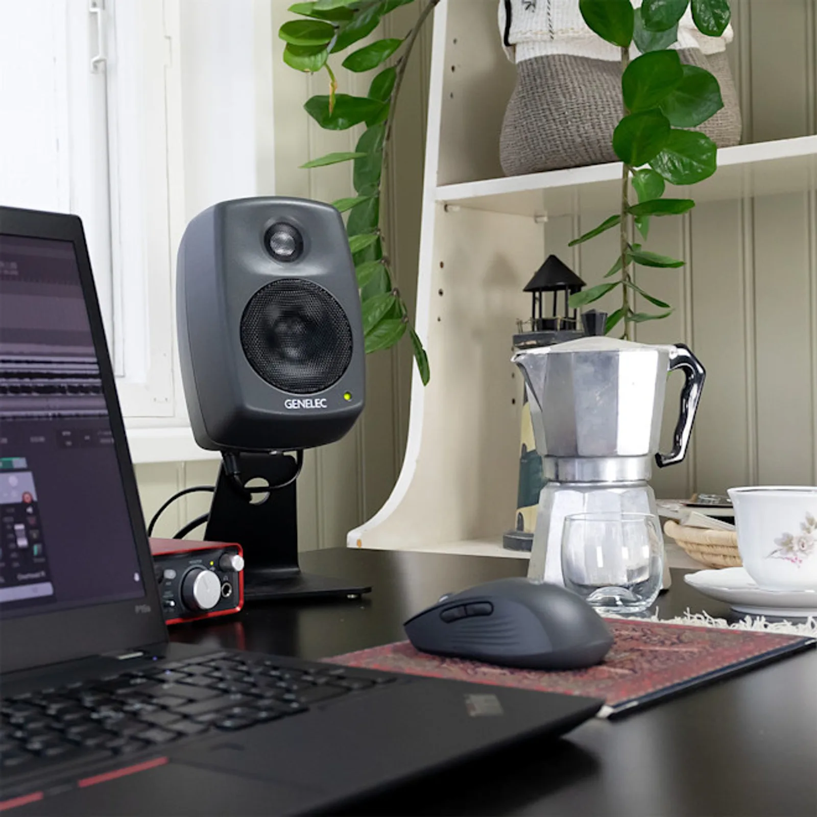 Cận cảnh Genelec 8010A đen: lưới woofer lục giác, tweeter phía trên trong waveguide, viền thùng cong
