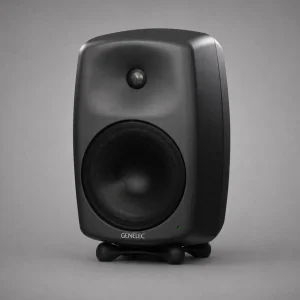 Genelec 8050B màu đen anthracite góc ba phần tư trên nền xám studio: MDE™, DCW™, woofer lưới, GENELEC trắng, LED xanh lá, Iso-Pod đen, ánh sáng mềm