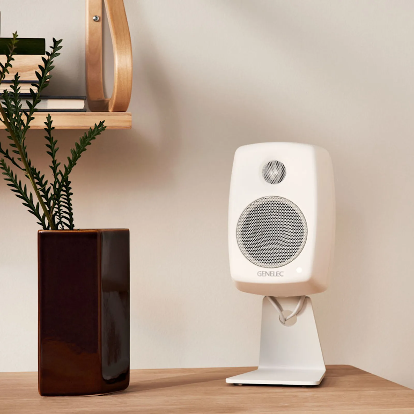 Bố cục catalog Genelec G One: hai loa trắng đối xứng trong khung ảnh vuông, nền sáng, phong cách sản phẩm gia dụng