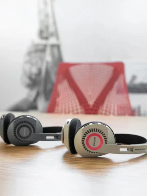 Hai tai nghe Koss KPH30 Wireless màu beige và xám đặt trên bàn gỗ, thiết kế on-ear open-back