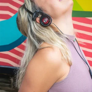 Người dùng đeo tai nghe Koss Porta Pro Utility on-ear, chụp tai đen viền đỏ và headband kim loại