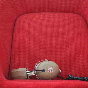 Tai nghe Koss PRO4AA over-ear đặt trên ghế đỏ, thiết kế studio cổ điển và cáp dày