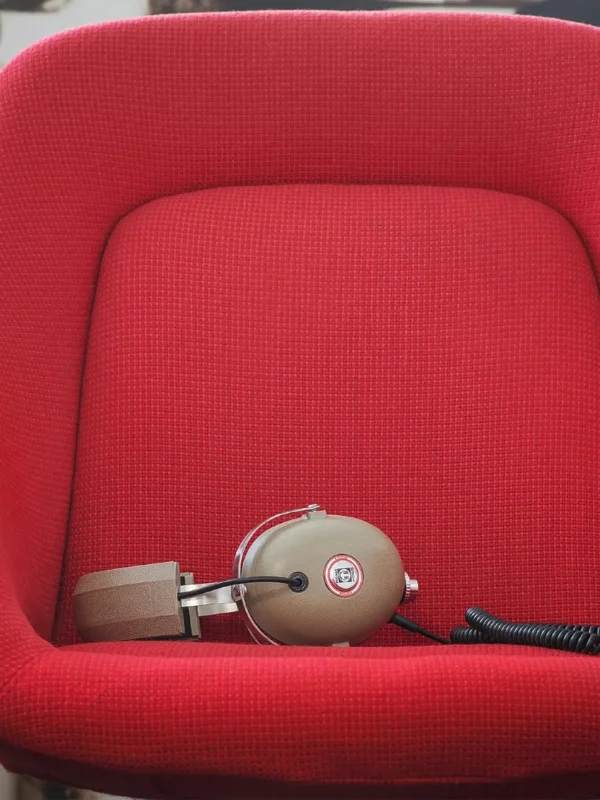Tai nghe Koss PRO4AA over-ear đặt trên ghế đỏ, thiết kế studio cổ điển và cáp dày