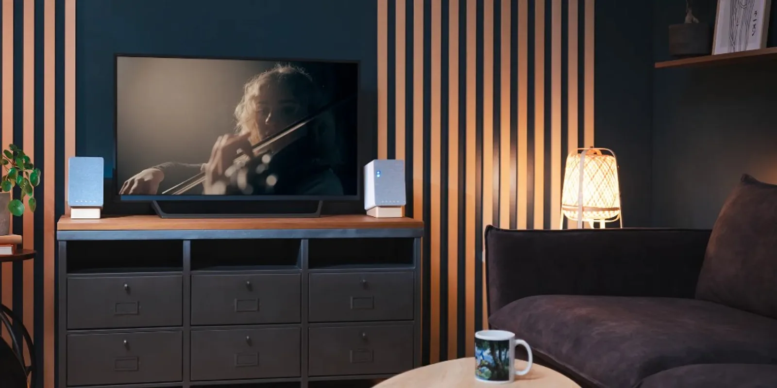 Loa Onkyo Creator GX-10DB hai bên TV trong phòng khách tối giản, đèn ấm và tường gỗ