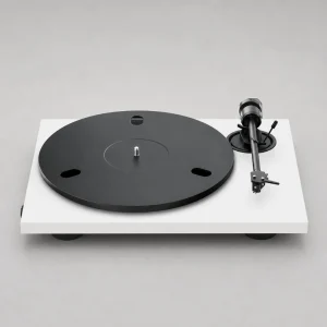 Mâm đĩa than Pro-Ject E1.2 phiên bản trắng: thân trắng mờ, platter đen có lỗ oval, tay cần thẳng đen với headshell và kim Ortofon OM, đối trọng tròn, công tắc tốc độ cạnh đế, chân giảm rung đen, nền xám studio