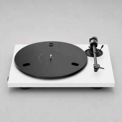 Mâm đĩa than Pro-Ject E1.2 phiên bản trắng: thân trắng mờ, platter đen có lỗ oval, tay cần thẳng đen với headshell và kim Ortofon OM, đối trọng tròn, công tắc tốc độ cạnh đế, chân giảm rung đen, nền xám studio