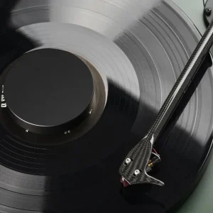 Pro-Ject Record Puck E màu đen trên nhãn đĩa vinyl, cần than carbon bên cạnh