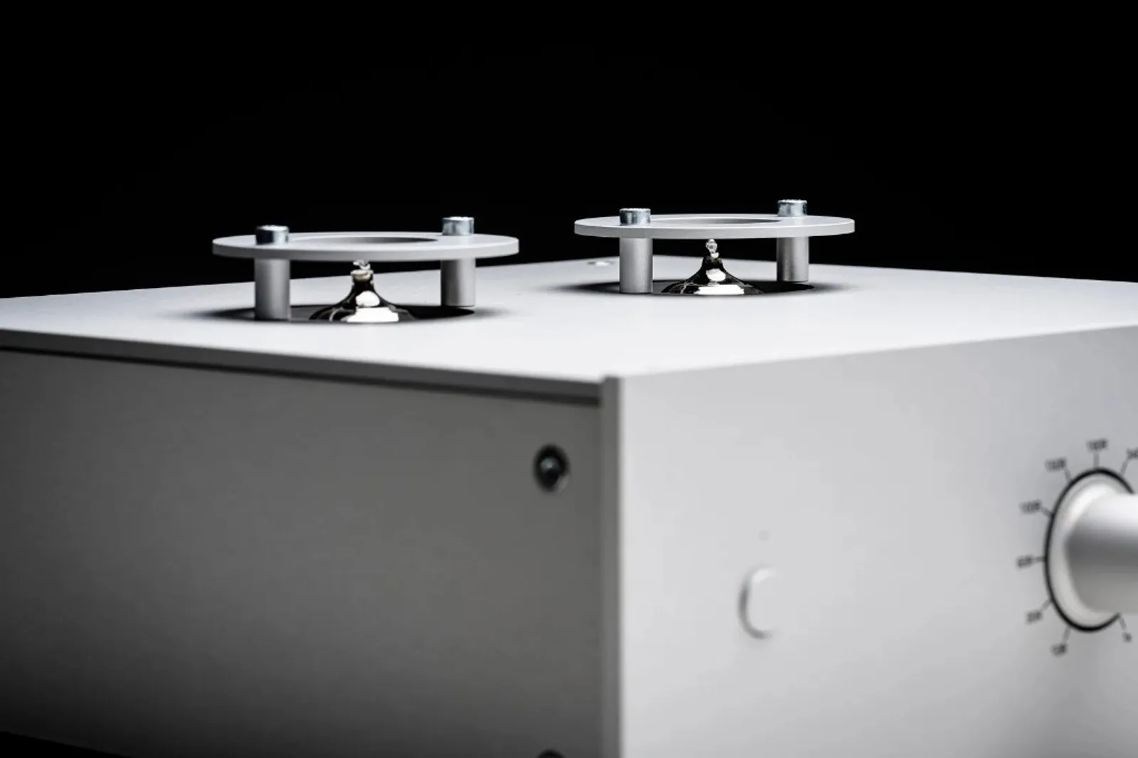 Cận cảnh Pro-Ject Tube Box DS3 B: hai bóng đèn trên nóc, núm volume/gain ở mặt trước, nền đen