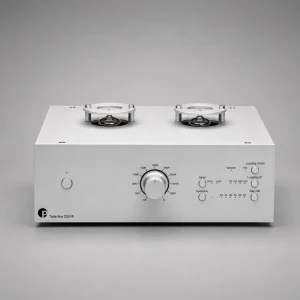 Pro-Ject Tube Box DS3 B màu bạc: hai bóng đèn trên nóc, núm lớn chỉnh loading và các nút input/subsonic/gain ở mặt trước, nền xám studio