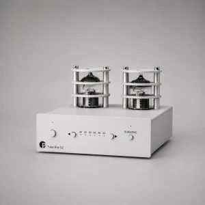 Pro-Ject Tube Box S2: phono preamp đèn vỏ nhôm bạc, hai bóng đèn chân không lộ thiên có khung bảo vệ, mặt trước có núm volume/gain và công tắc subsonic, nền xám studio