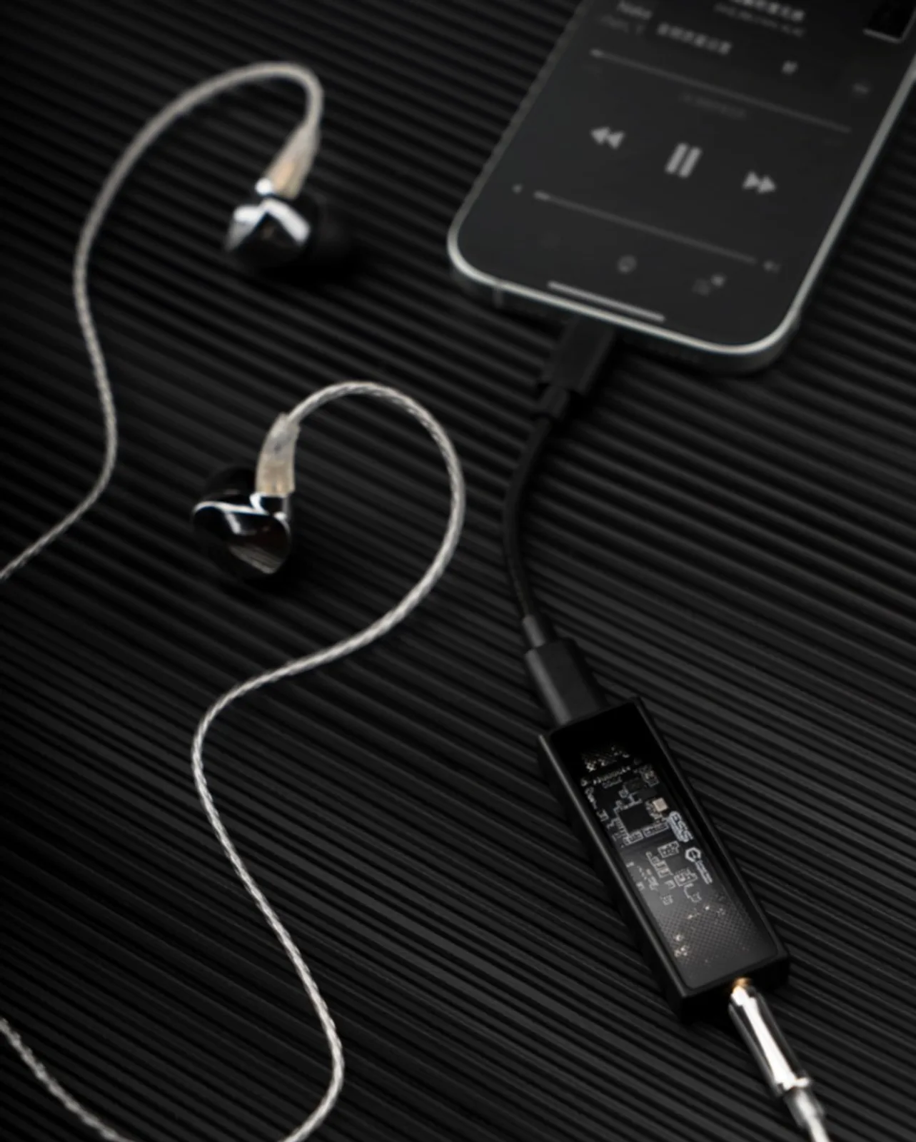 Minh họa Questyle M12i: bên trái nối laptop qua USB-C, bên phải nối iPad đang phát nhạc với tai nghe in-ear — DAC/Amp di động jack 3,5 mm cho máy tính và máy tính bảng.