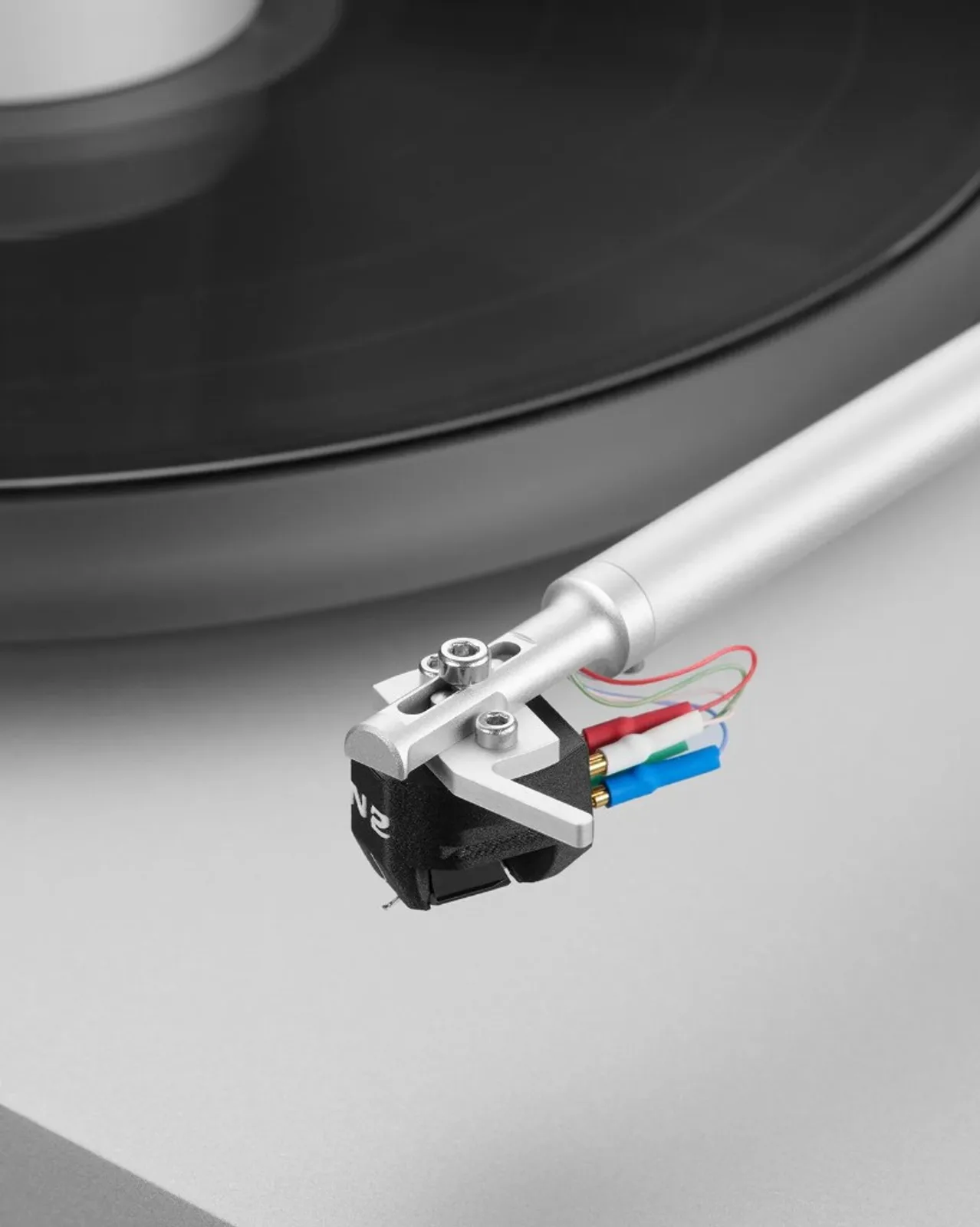 Clearaudio N2 trên headshell nhôm bạc, dây nối đỏ trắng xanh lá xanh dương, tonearm và mâm đĩa đen