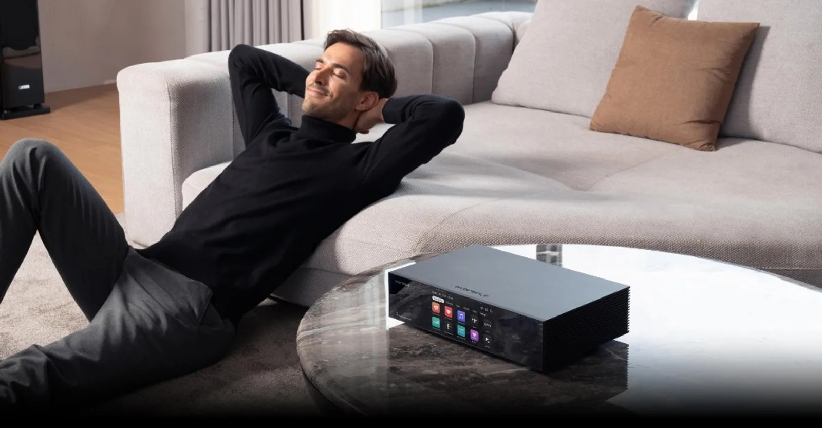 Eversolo T8 trên bàn trà đá cẩm thạch, người dùng thư giãn nghe nhạc trên sofa, màn hiển thị app streaming