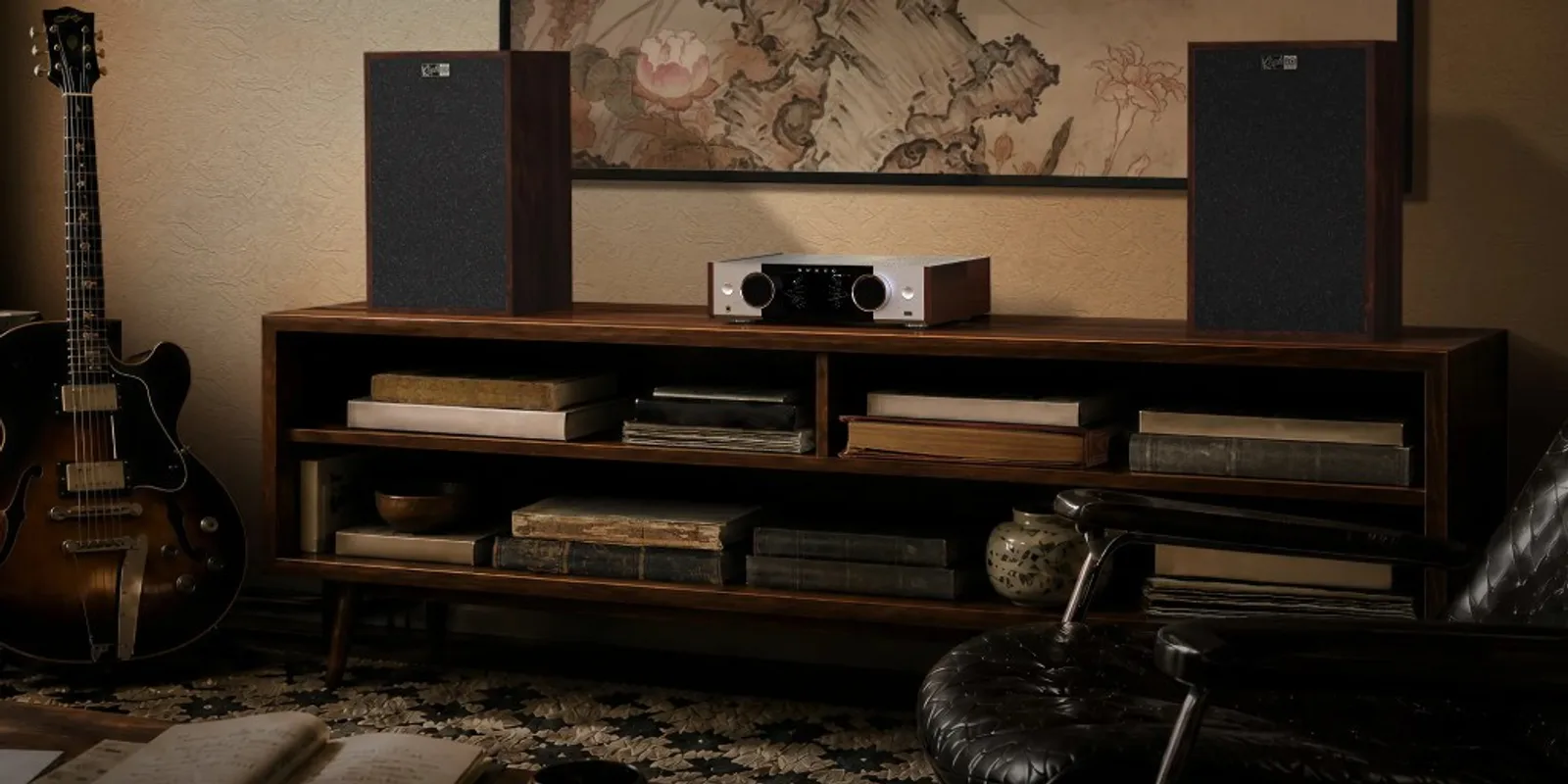 Hệ Onkyo Muse Y-50 giữa cặp loa bookshelf trên kệ gỗ, guitar và tranh treo tường trong phòng nghe