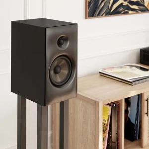 Loa Revival Audio SPRINT 3 màu Matte Black trên chân loa, góc nghiêng cạnh kệ đĩa than trong phòng khách