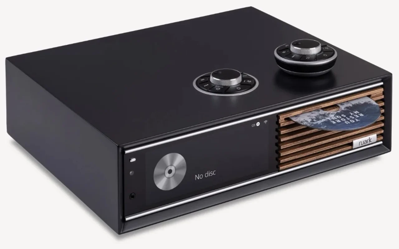 Ruark R710 màu đen với màn hiển thị, grille gỗ, khe CD và RotoDial tích hợp kèm remote tròn, nền trắng