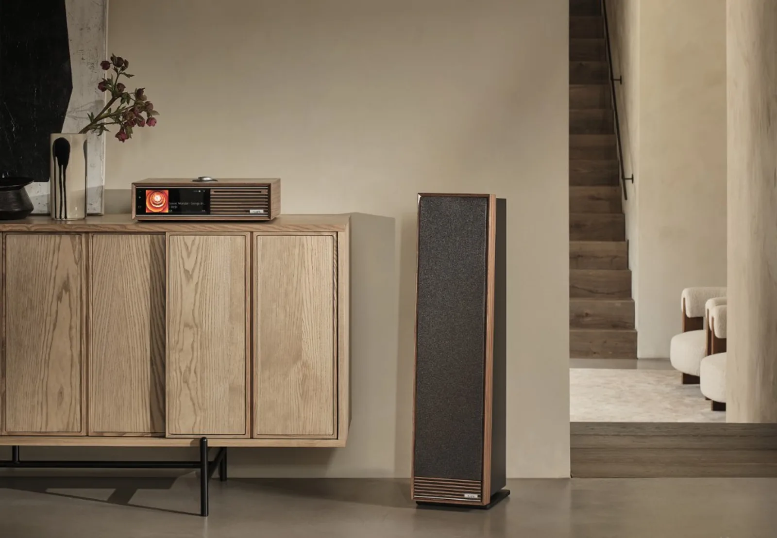 Hệ Ruark trong phòng khách: music system gỗ trên kệ và loa tower kèm, thiết kế walnut đồng bộ