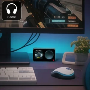 SMSL Nano One đen trên bàn gaming với màn hình game, bàn phím và chuột, ánh sáng xanh