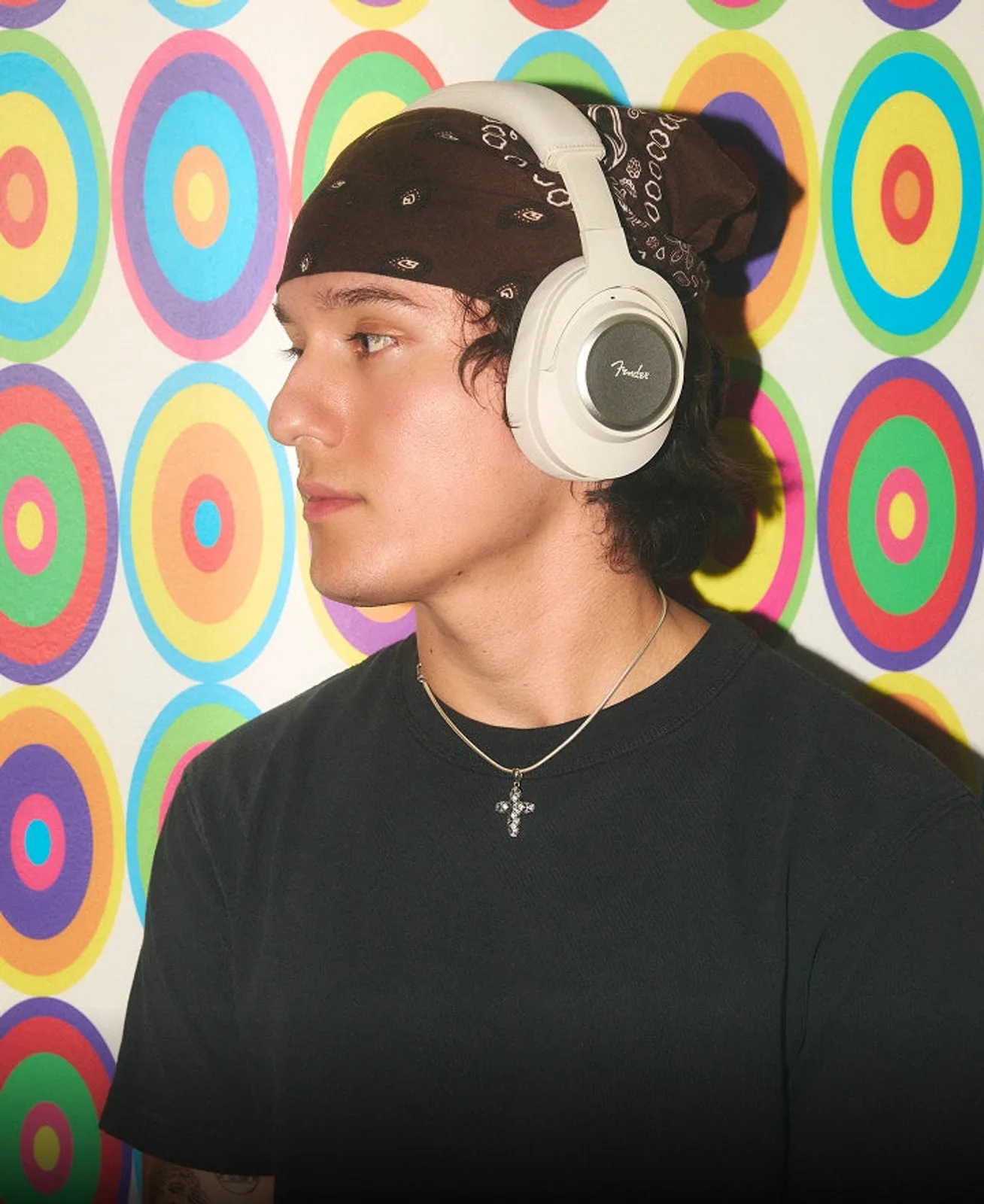 Fender Mix đen đeo ngoài trời buổi chiều, logo vàng trên earcup, ánh sáng lens flare ấm