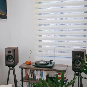Revival Sprint 3 trên chân tripod và mâm Pro-Ject Debut EVO 2 xanh trên kệ gỗ sách