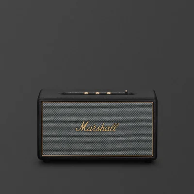 Marshall Stanmore IV đen mặt trước với lưới vải xám salt-and-pepper và logo Marshall vàng đồng