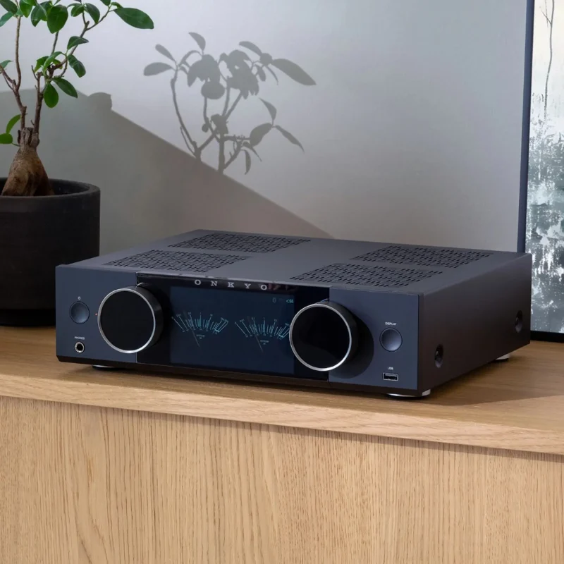 Onkyo Muse Y-40 đen trên kệ gỗ với đồng hồ VU xanh và cây xanh trang trí