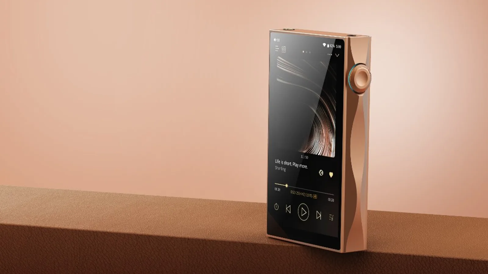 Shanling M3 Plus màu mocha đứng trên bàn da nâu, màn 4.7 inch và núm volume viền xanh