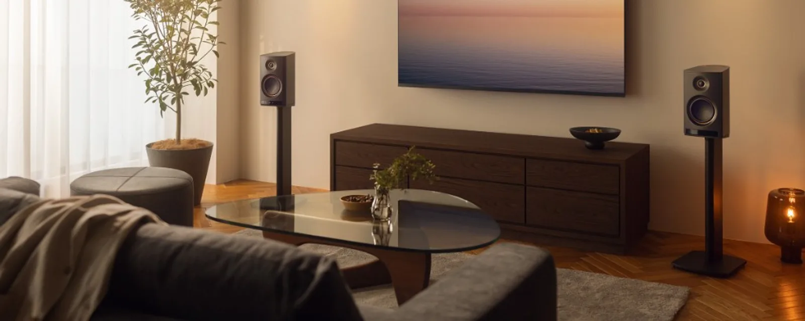 Đôi loa Yamaha NX-70A đen trên chân đứng, phòng khách hiện đại với TV và bàn gỗ