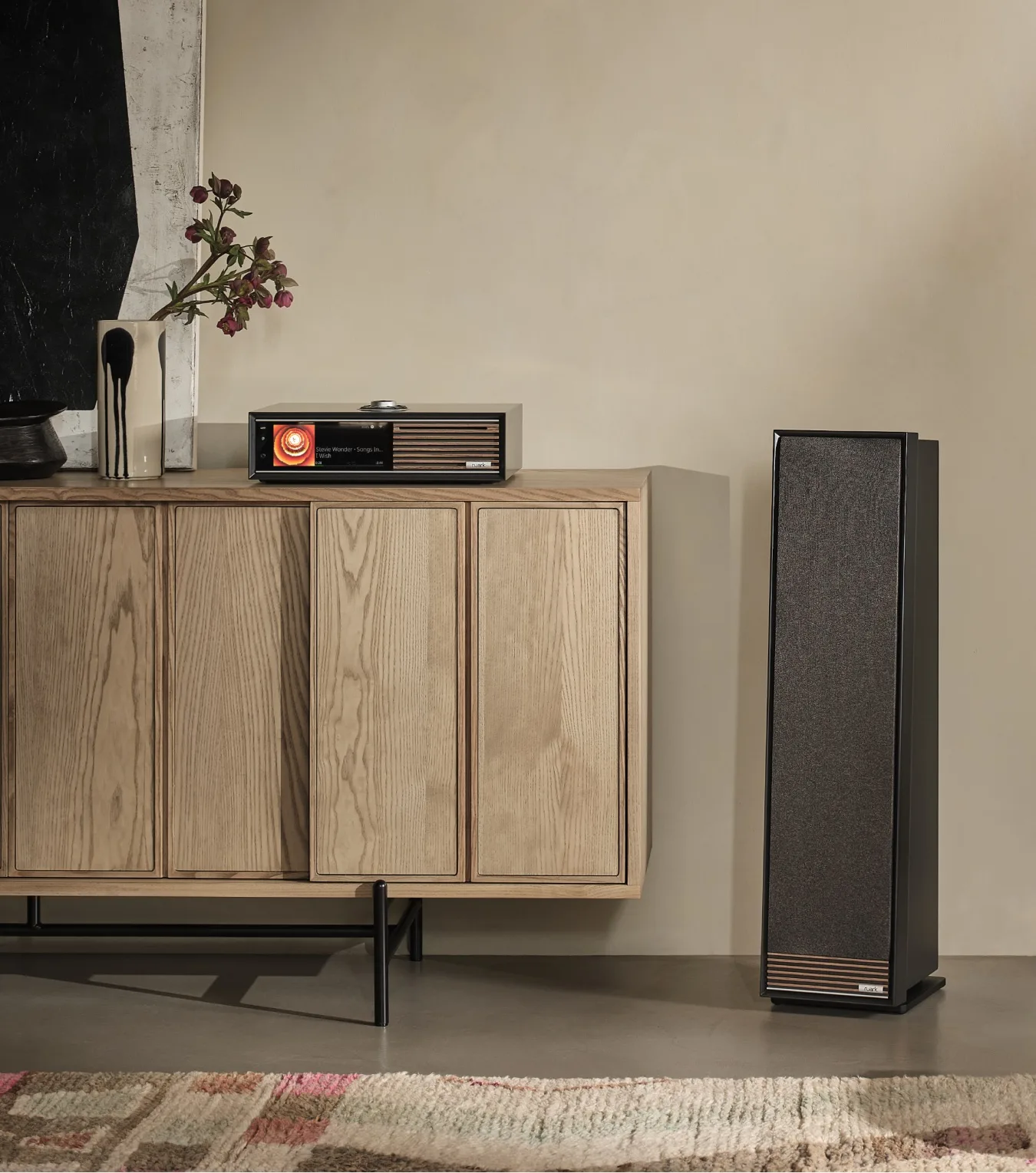 Talisman-R Satin Charcoal cạnh Ruark R610 trên tủ gỗ, tranh trừu tượng