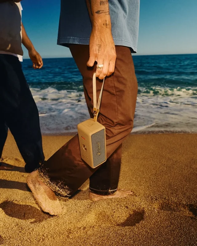 Người mang Marshall Emberton III Brown bằng dây đeo trên bãi biển